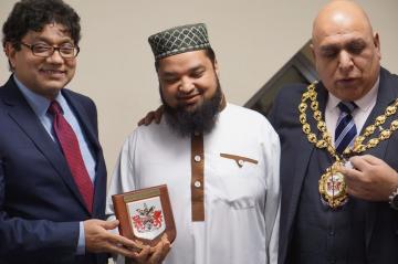 Helal receiving commemorative award from Oldham Council